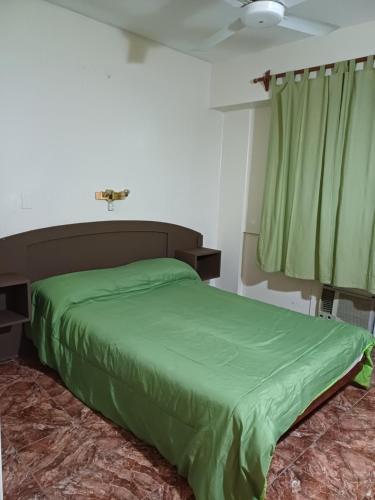 a bedroom with a green bed and a fan at Hotel PANAME, CERCA DE LA RURAL , EMBAJADA EEUU , HIPÓDROMO DE PALERMO Y CAMPO DE POLO in Buenos Aires