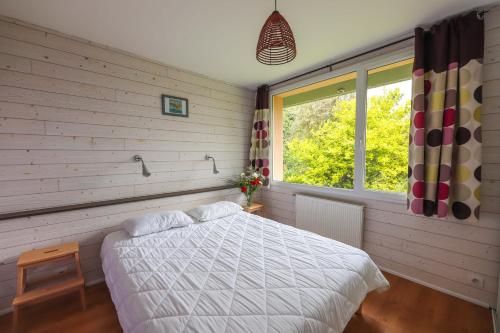 a bedroom with a white bed and a window at Résidence de Nodeven in Guissény