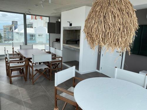 a dining room with tables and chairs and a chandelier at Moderno apartamento en península in Punta del Este