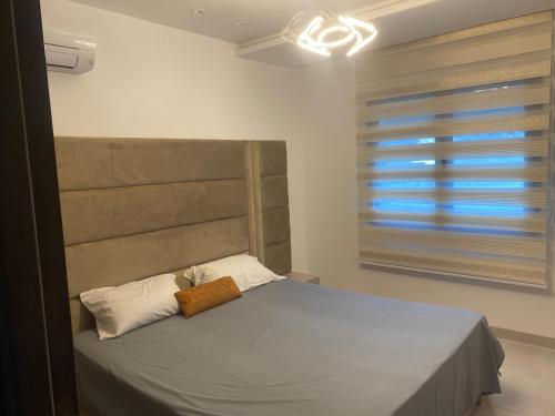 une chambre avec un grand lit avec une grande fenêtre dans l'établissement Bo app aïn zaghouén la marsa, à La Marsa