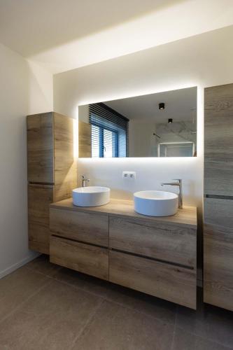 a bathroom with two sinks and a large mirror at Villa Armande in Zammelen