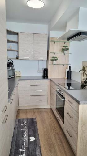 Una cocina con gabinetes de madera y electrodomésticos de acero inoxidable. en apartment77, en Bad Ischl