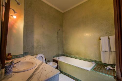 a bathroom with a sink and a tub and a toilet at Riad - Dar Al Andalous in Fès