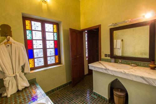 a bathroom with a sink and a stained glass window at Riad - Dar Al Andalous in Fès