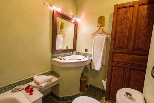 a bathroom with a sink and a toilet and a mirror at Riad - Dar Al Andalous in Fès