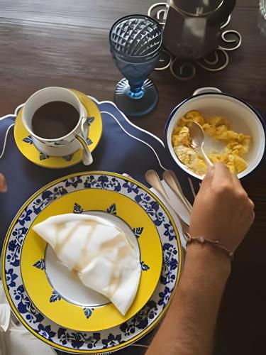 a table with plates of food and a cup of coffee at Vila Corada in Pipa
