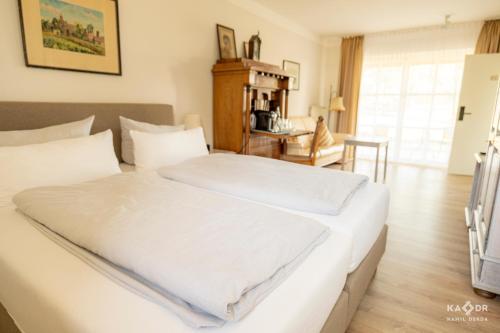 Postel nebo postele na pokoji v ubytování Landhotel Rosenhof am Plauer See garni mit E-Lade Säule