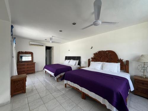ein Schlafzimmer mit zwei Betten und einem Deckenventilator in der Unterkunft Casa Toadfish in Cozumel
