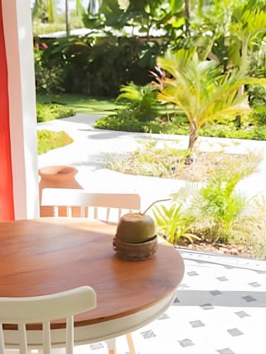 a table and chairs on a patio with a garden at Vila Corada in Pipa