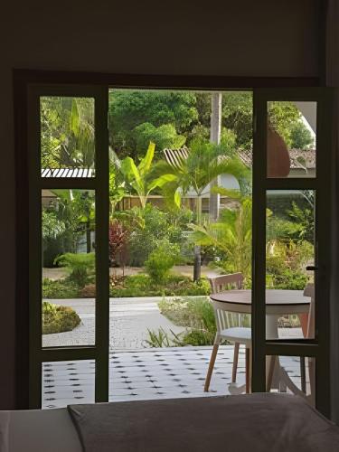 a room with a window looking out at a garden at Vila Corada in Pipa