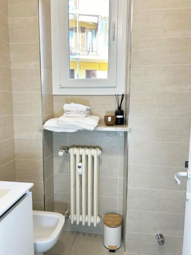 a bathroom with a radiator and a sink and a mirror at QuickHome - Appartamento Mazzini in Biella