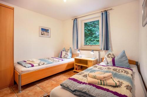 Un dormitorio con dos camas y una ventana en Prerow Am Deich - Ferienwohnung 4, en Prerow