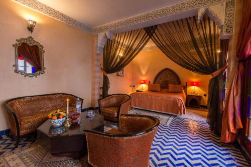 a bedroom with a bed and a table and chairs at Riad - Dar Al Andalous in Fès