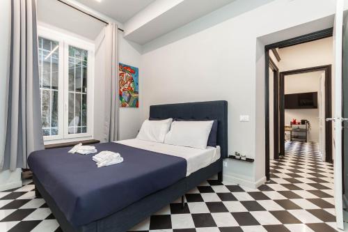 1 dormitorio con 1 cama azul y suelo a cuadros en DolceVita Portofino, Central Square, Ground Floor, AC, en Portofino