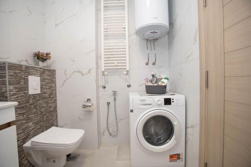 a bathroom with a washing machine and a toilet at Urban Living in Gevgelija