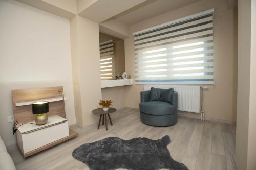 a living room with a blue chair and a window at Urban Living in Gevgelija