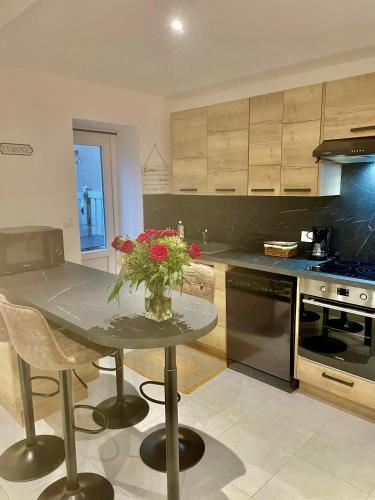 une cuisine avec une table avec un vase de fleurs dessus dans l'établissement La Villa Saint Louis, à Étretat