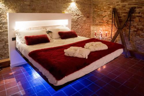 a bedroom with a large bed with towels on it at Inferno e Paradiso in Gradara
