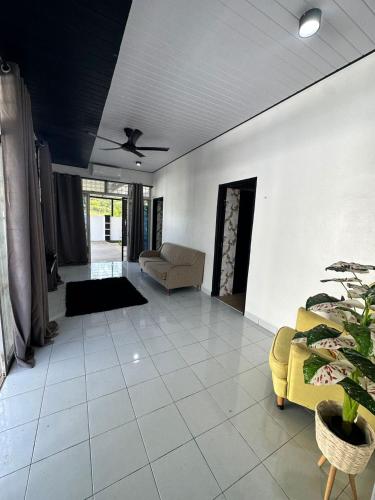 a living room with a couch and a ceiling fan at Diemaz Homestay in Sungai Petani