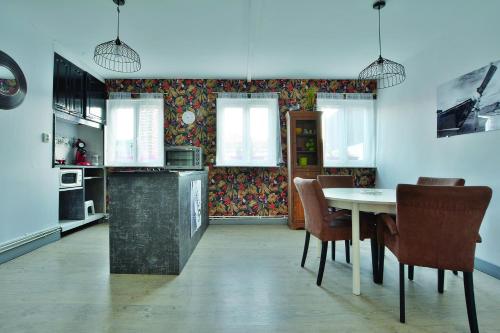 une cuisine avec une table et des chaises dans une pièce dans l'établissement Gite de la Baie des Phoques, à Saint-Valery-sur-Somme