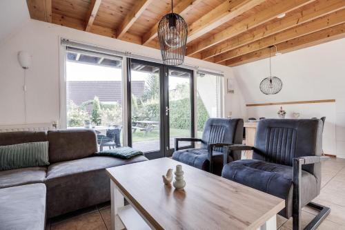 ZwiggelteにあるOrtelaan I Prettig Huis met Gezellige Tuinのソファと椅子とテーブルのあるリビングルーム