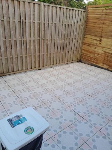 a backyard with a fence and a white table at Charming F2 in Sainte-Anne