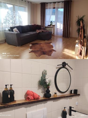 a living room with a couch and a mirror at Naturblick in Baiersbronn