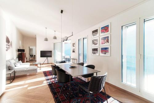 a living room with a dining room table and chairs at Unique Gandria Attic by Quokka 360 - Elegant Lake View Apartment in Lugano