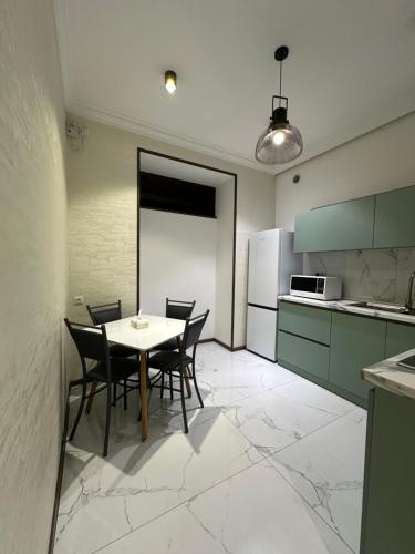 una cucina con tavolo, sedie e frigorifero di Saryan House a Yerevan