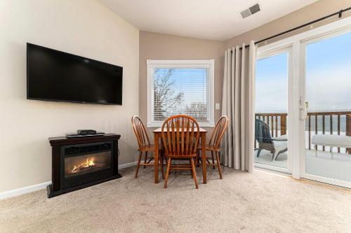 a dining room with a table and chairs and a fireplace at Beachside 322 Waterfront Condo in Traverse City