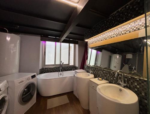 La salle de bains est pourvue de 2 lavabos, d'une baignoire et d'un lave-linge. dans l'établissement Grand Duplex Rosella Hightower, à Cannes