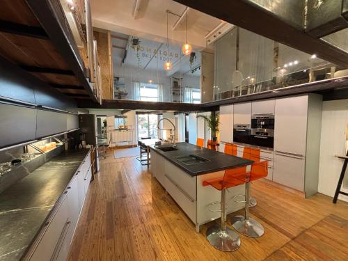 une grande cuisine avec des chaises orange et une grande île dans l'établissement Grand Duplex Rosella Hightower, à Cannes