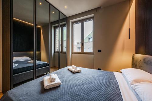 due asciugamani su un letto in una stanza con specchio di Luxury Suite with View Steps from the Duomo a Milano