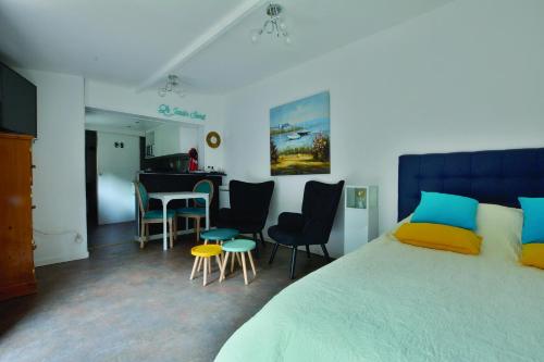 - une chambre avec un lit, des chaises et une table dans l'établissement gîte du jardin secret, à Saint-Valery-sur-Somme