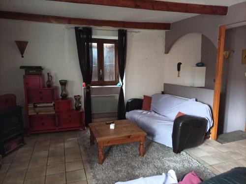 a bedroom with a bed and a coffee table at charmante maison ardechoise in Vogüé