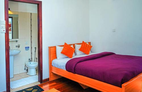 Un dormitorio con una cama y un baño con inodoro. en Mountain Breeze Apartment, en Nuwara Eliya