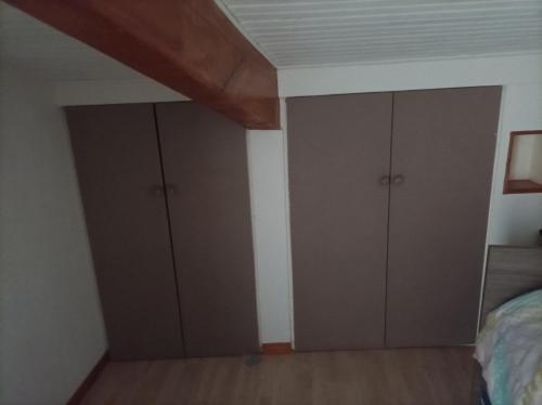 a bedroom with two closets and a bed at charmante maison ardechoise in Vogüé