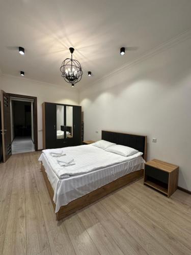 una grande camera da letto con un letto grande e un lampadario di Saryan House a Yerevan