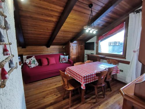 a living room with a table and a couch at Mansarda trilocale direttamente sulla pista a Folgarida - Belvedere in Folgarida