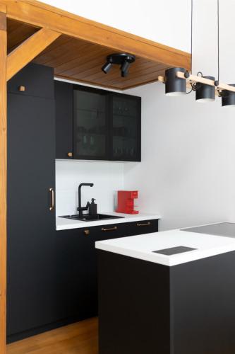 a kitchen with a sink and a black and white counter at Gorska Vila in Kopaonik