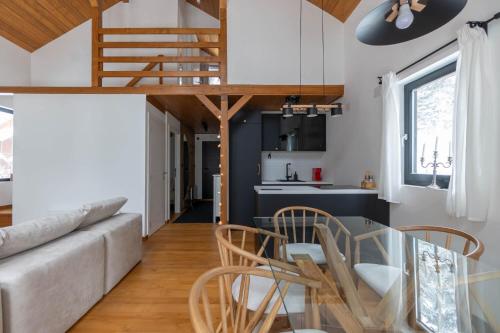 a living room with a couch and a table and chairs at Gorska Vila in Kopaonik