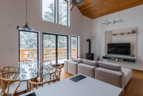 a living room with a couch and a table and chairs at Gorska Vila in Kopaonik