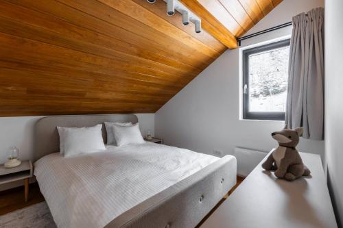 a bedroom with a large bed with a teddy bear sitting next to it at Gorska Vila in Kopaonik