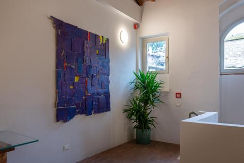 a room with a painting on the wall and a plant at Dimora Storica Antica Grancia in Rapolano Terme