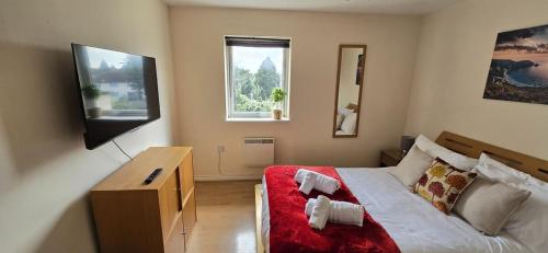 a bedroom with a large bed and a television at SAV Stays Apartment Two Bed Flat Uxbridge in Uxbridge