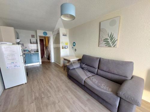 un salon avec un canapé et une cuisine dans l'établissement STUDIO 1ERE LIGNE MER AVEC PKG QUARTIER CORNICHE, à Sète