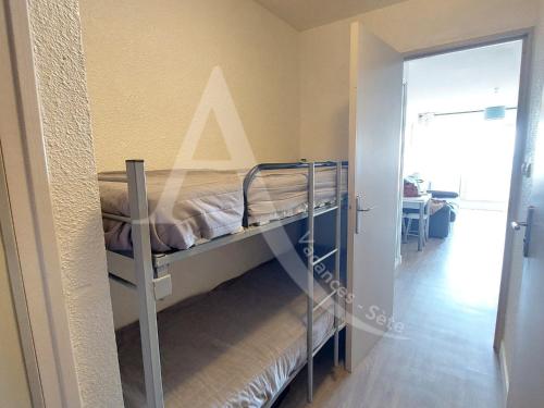 une chambre avec un lit superposé dans une pièce dans l'établissement STUDIO 1ERE LIGNE MER AVEC PKG QUARTIER CORNICHE, à Sète