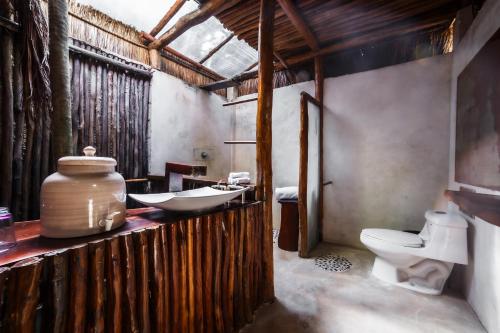 a bathroom with a toilet and a sink and a tub at Eco Bañitas Tulum in Tulum