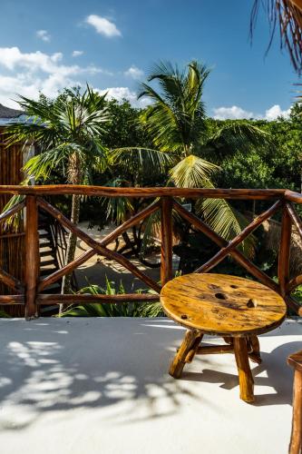a wooden bench sitting next to a wooden fence at Eco Bañitas Tulum in Tulum
