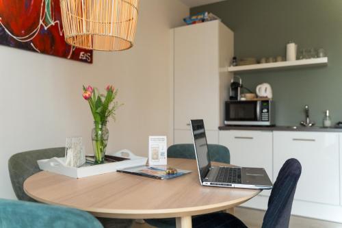 a dining room table with a laptop computer on it at Hof Olmenstein in Goes